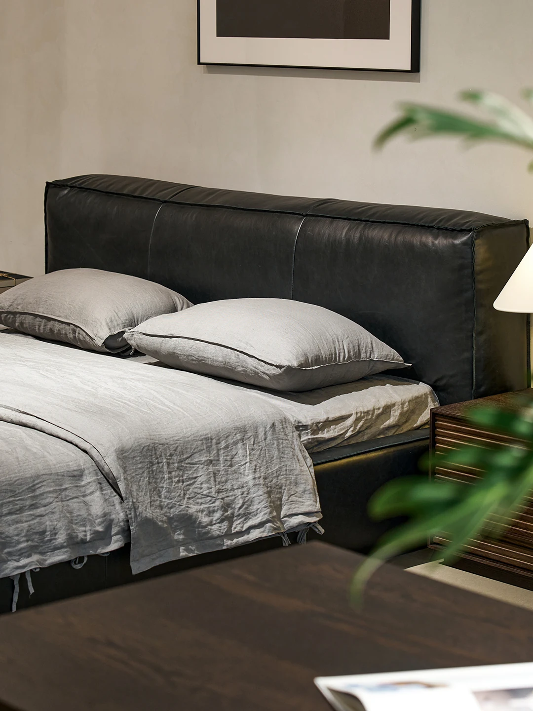 Sori black leather bed dressed with relaxed grey linen
