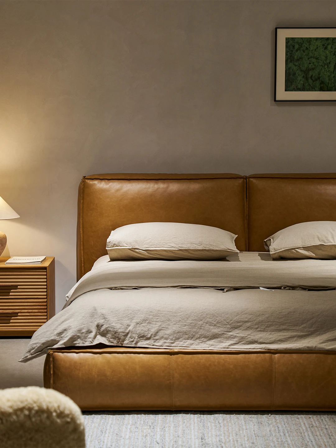Warm leather Yawa bed with loose neutral linen